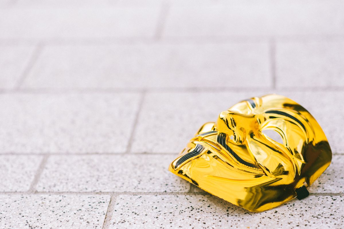 A gold mask lying on the ground.