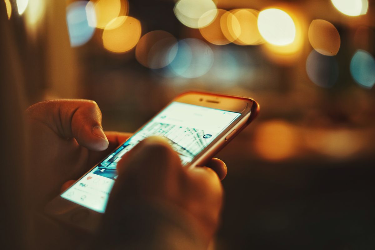 A person holding a smartphone while viewing a local business profile.